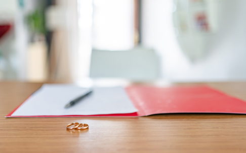 Wedding rings in front of documents in a folder
