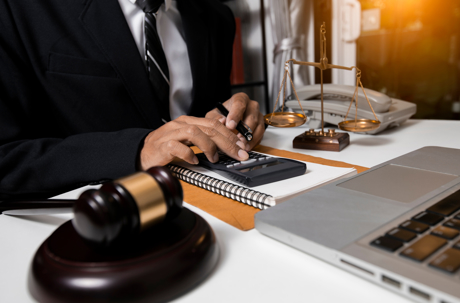 Lawyer using calculator while looking at documents