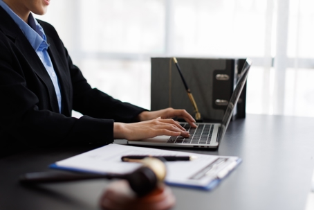 Attorney typing on computer at their desk